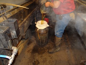 The boiling syrup is filtered in small batches before it is put in stainless steel drums